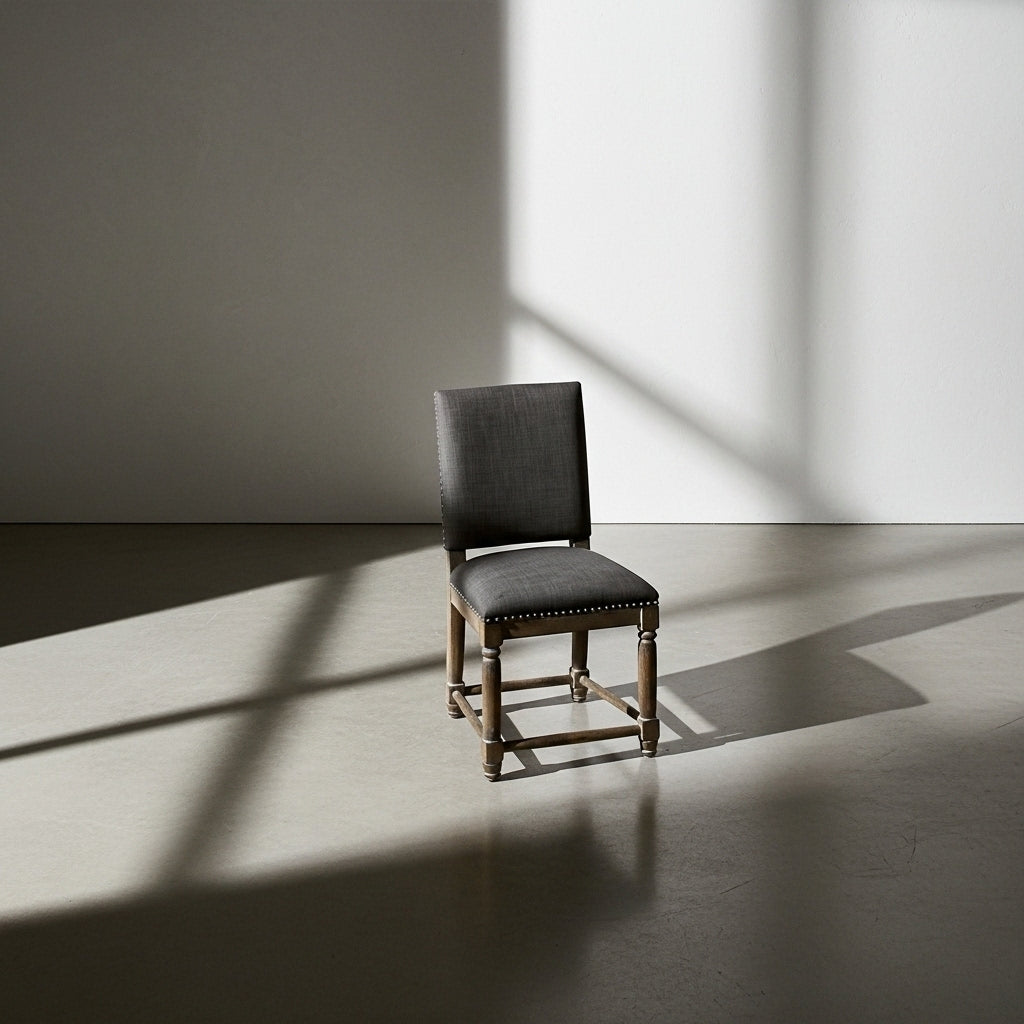 Dark gray chair in a room with sunlight casting shadows on the floor