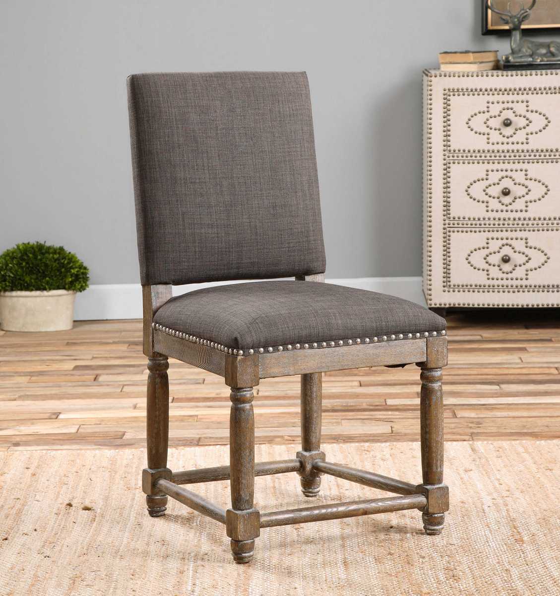 Gray upholstered chair with wooden legs in a room setting.