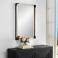 Nautical Mirror with White Rope frame and black corners over hanging a wood black console with flowers and an ocean view.