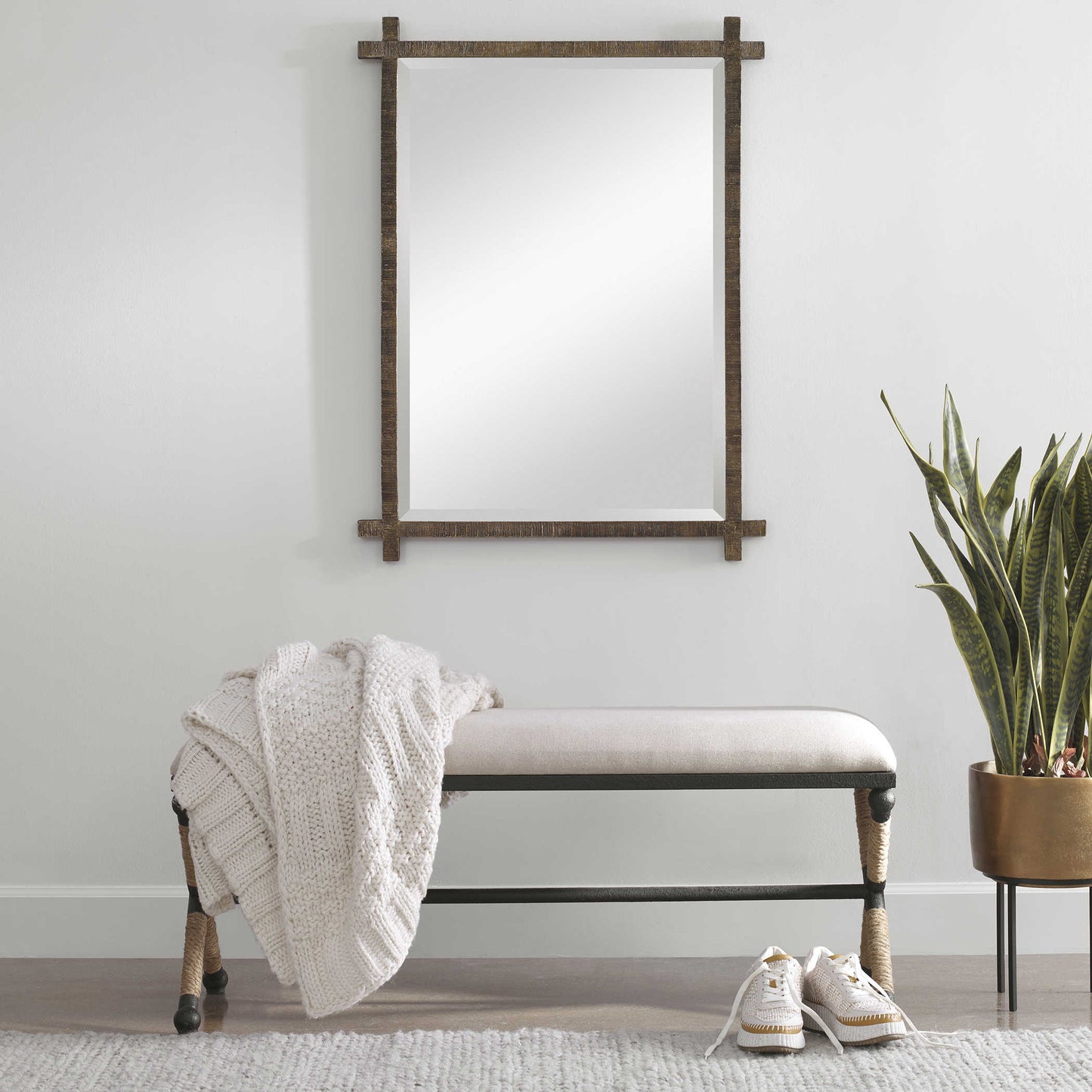 White upholstered bench with metal frame and rope accents in a coastal living room.