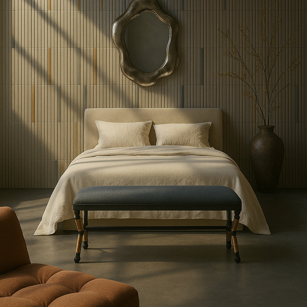 Neatly made bed with beige bedding in a room with wooden wall paneling and a decorative mirror.