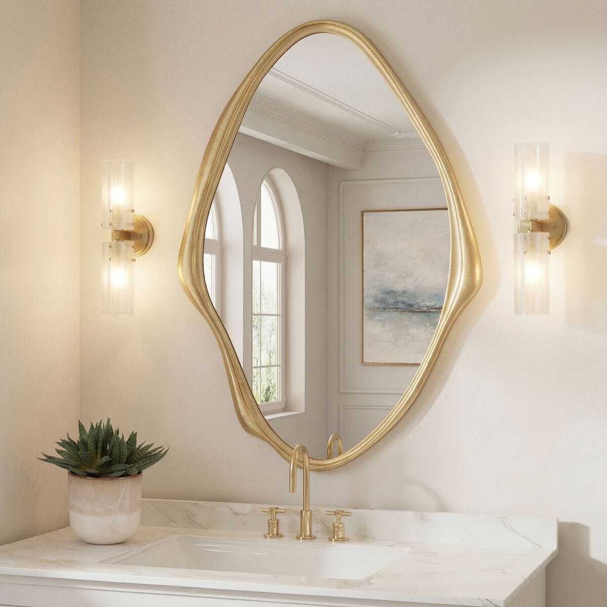 Bathroom with a gold-framed mirror, sink, and wall lights.