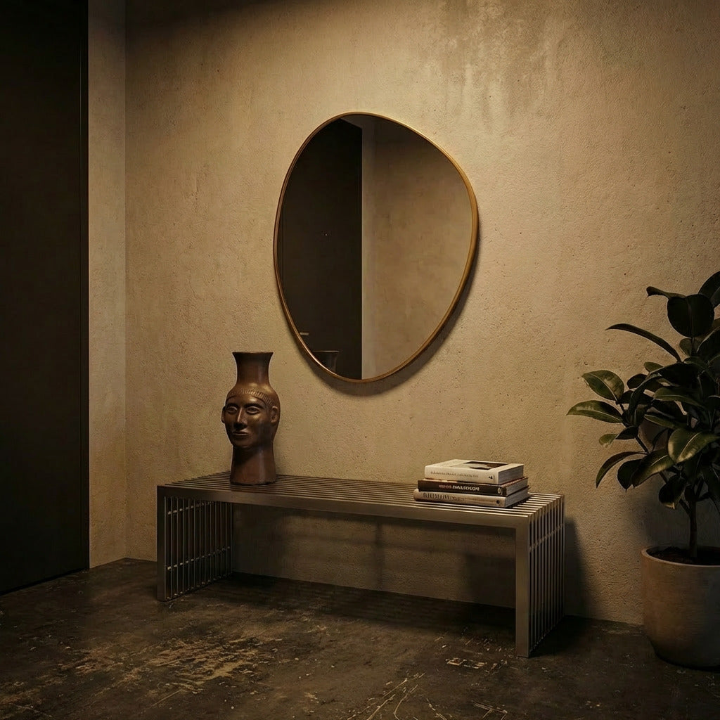 Round mirror on a textured wall above a wooden console table with decorative items.