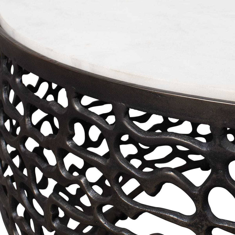 Close-up of a decorative metal stool with intricate lattice design on a white background