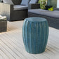 Teal garden stool on the patio with outdoor furniture.