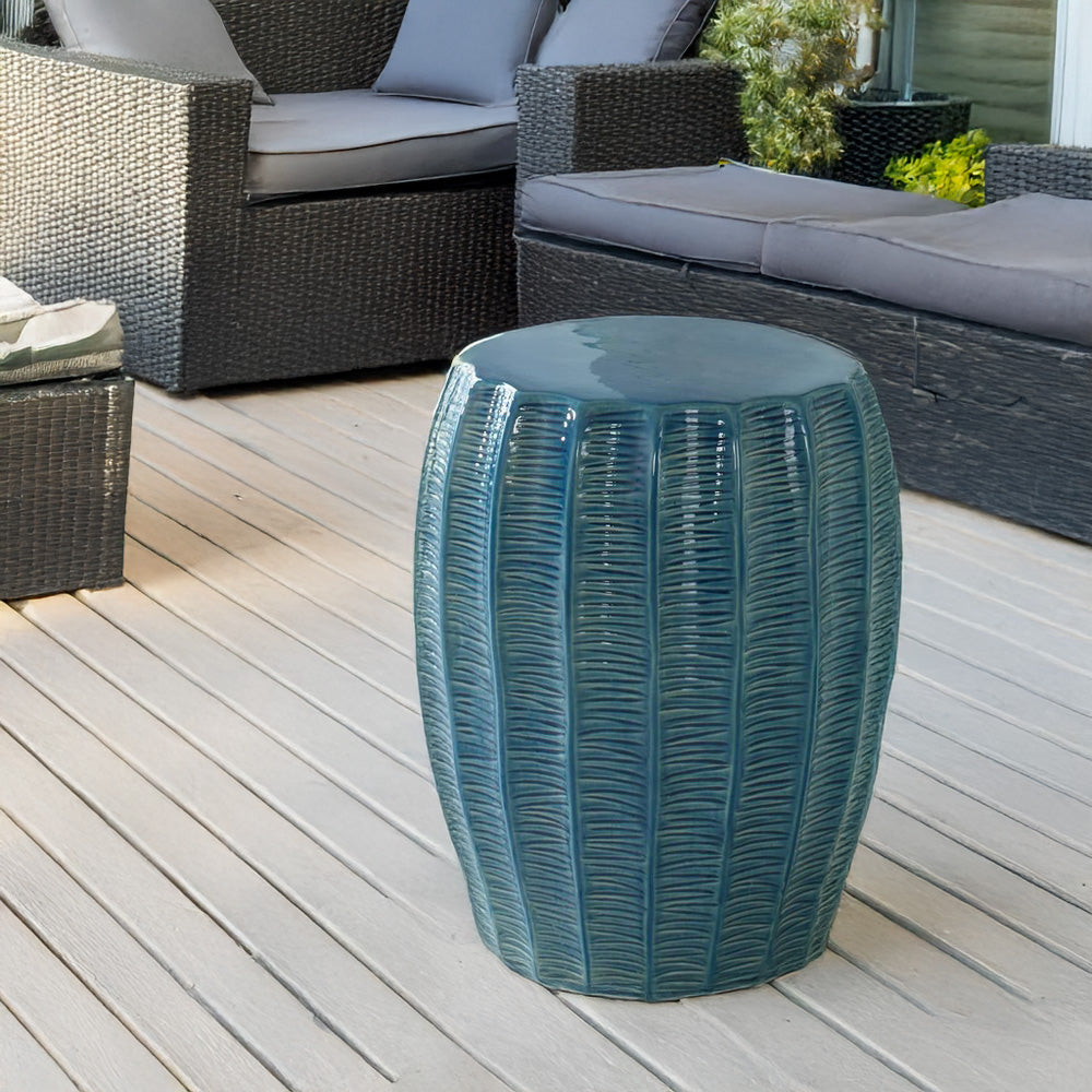 Teal garden stool on the patio with outdoor furniture.