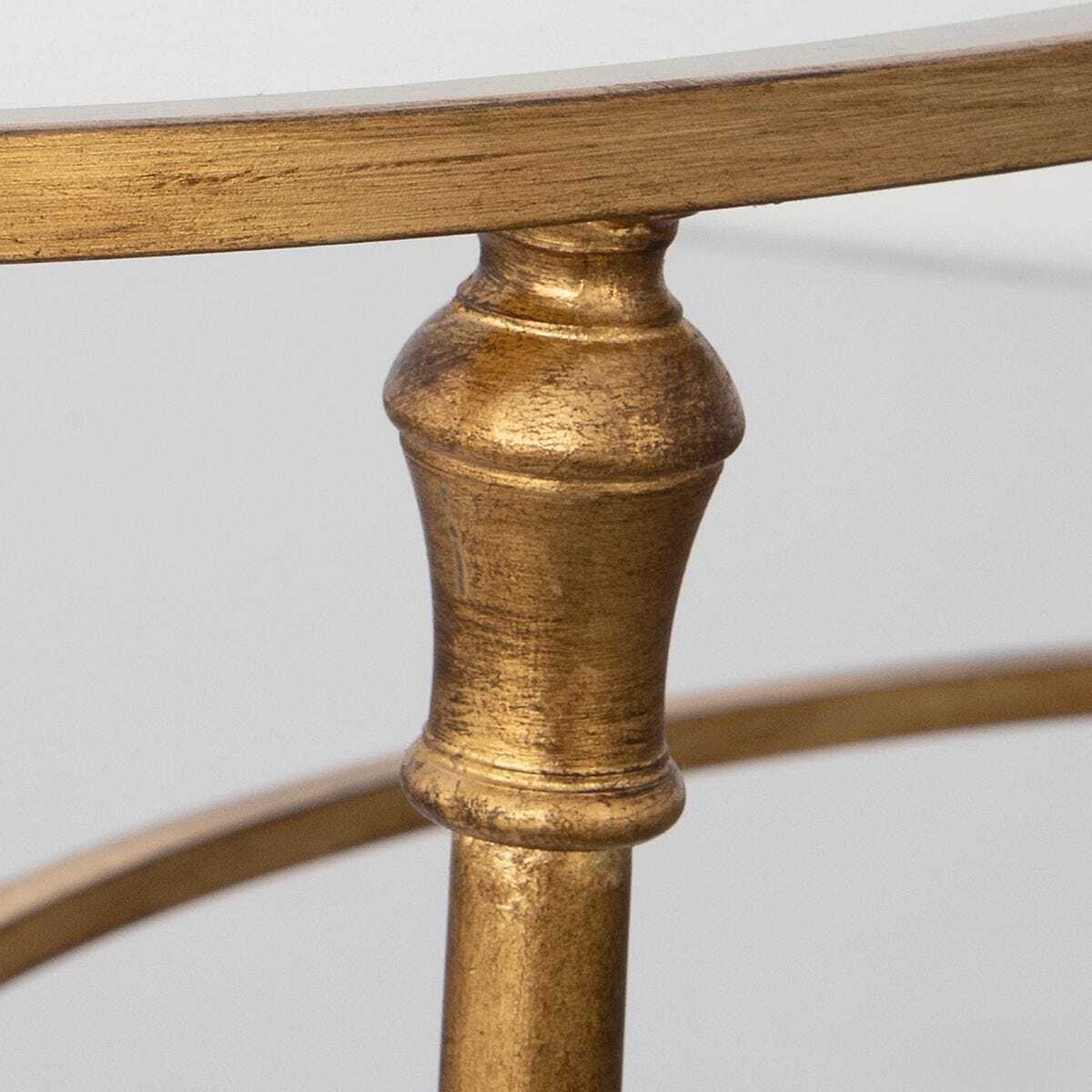 Close-up of a gold metal table leg with a white background