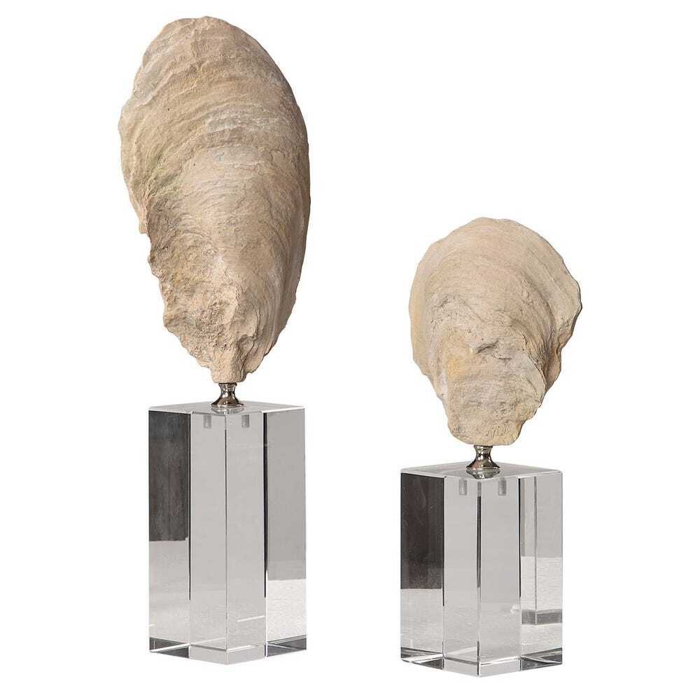 Two large oyster sculptures on clear stands against a white background