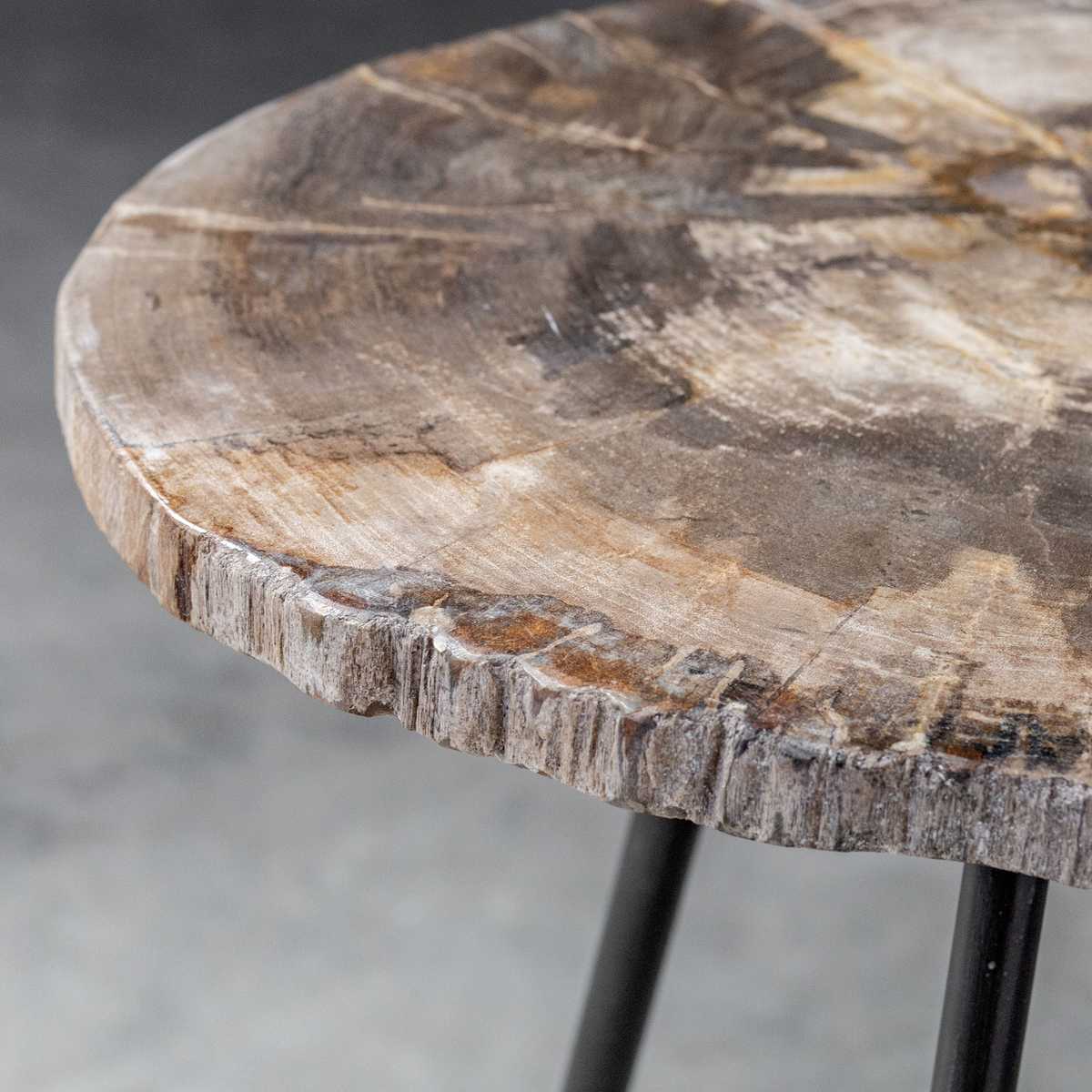 Round wooden table with a natural, textured surface on a blurred gray background