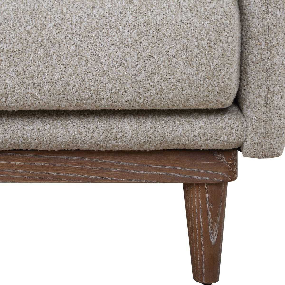 Close-up of a beige textured sofa with wooden legs on a white background