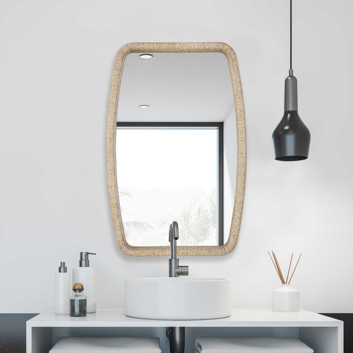Bathroom vanity with mirror, sink, and decorative items on a white wall.