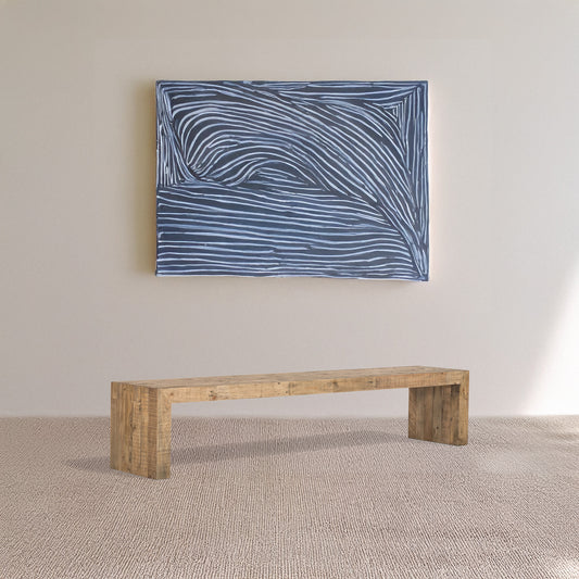 Reclaimed wood bench on carpet with an abstract piece of art with white lines hung on the wall behind it.