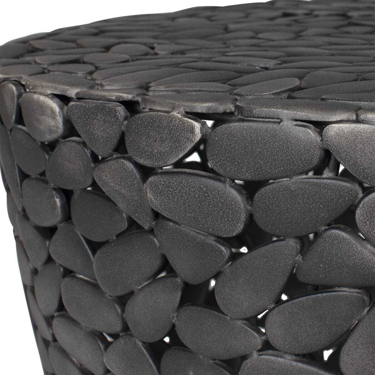 Close-up of a woven black stone stool with a textured surface.