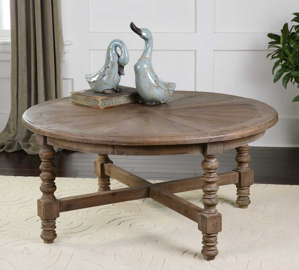 Round wooden table with decorative items on a light-colored floor.