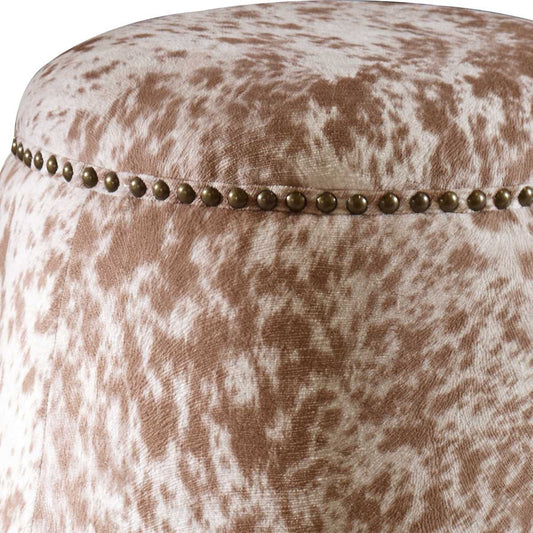 Round cowhide ottoman with brass detailing.