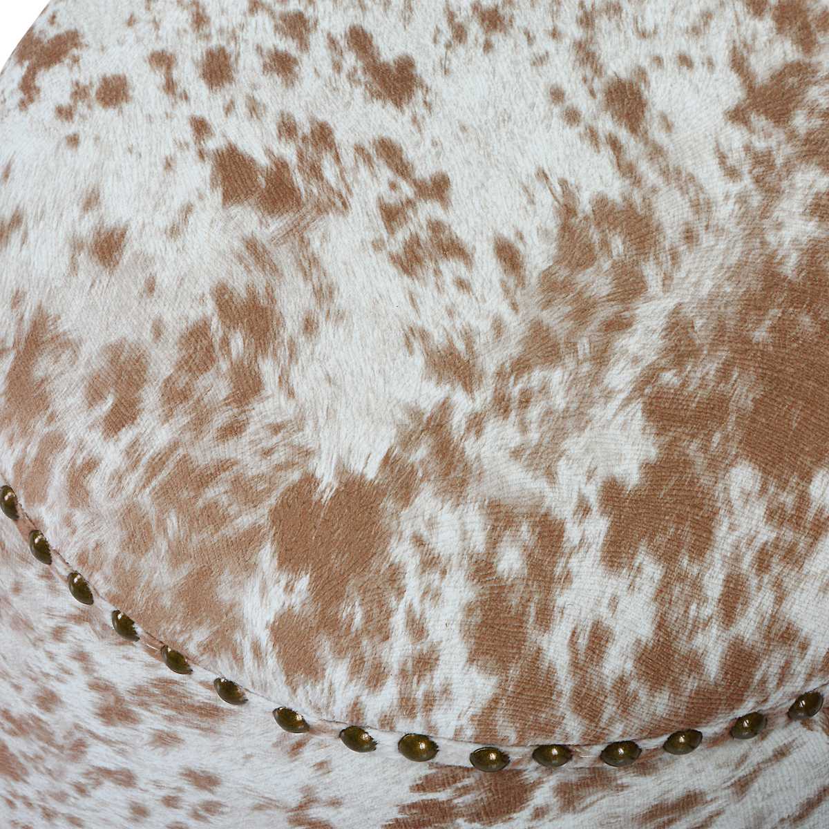 Close up of round cowhide ottoman.