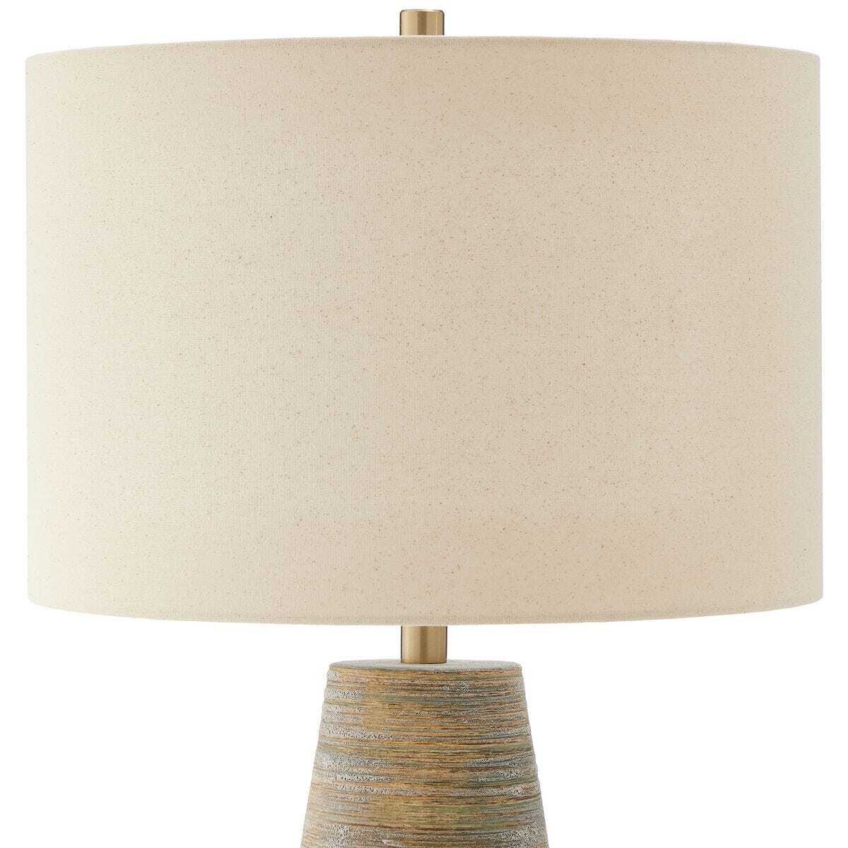 Table lamp with a beige fabric shade and textured base on a white background