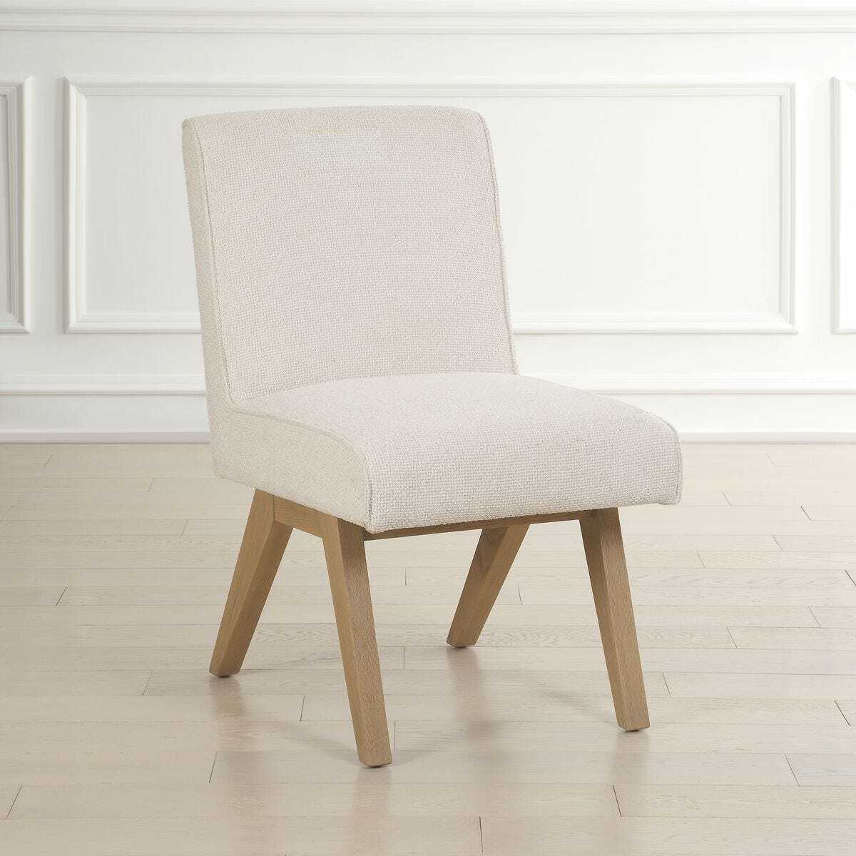 Beige upholstered chair with wooden legs on a light wooden floor.