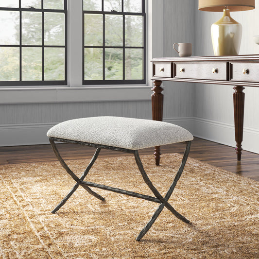 Small bench with gray cushion and distressed metal legs in a transitional living room with contemporary rug in yellow.