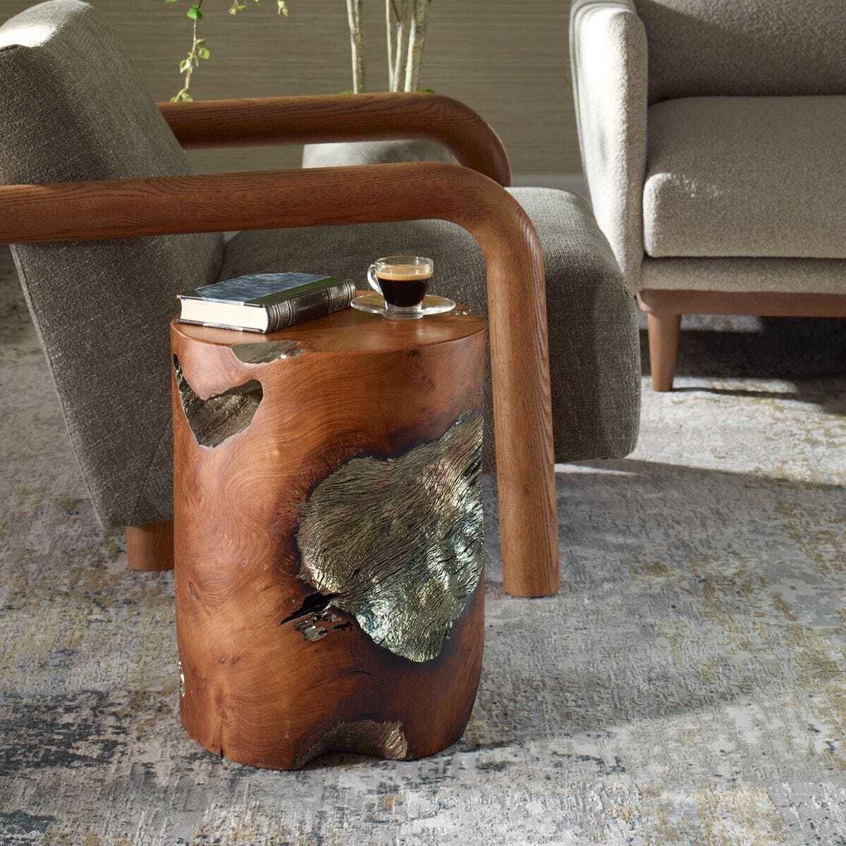 Teak side table with natural finish and leaf decorations in a living room setting.