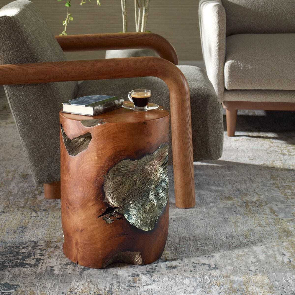 Teak side table with natural finish and leaf decorations in a living room setting.