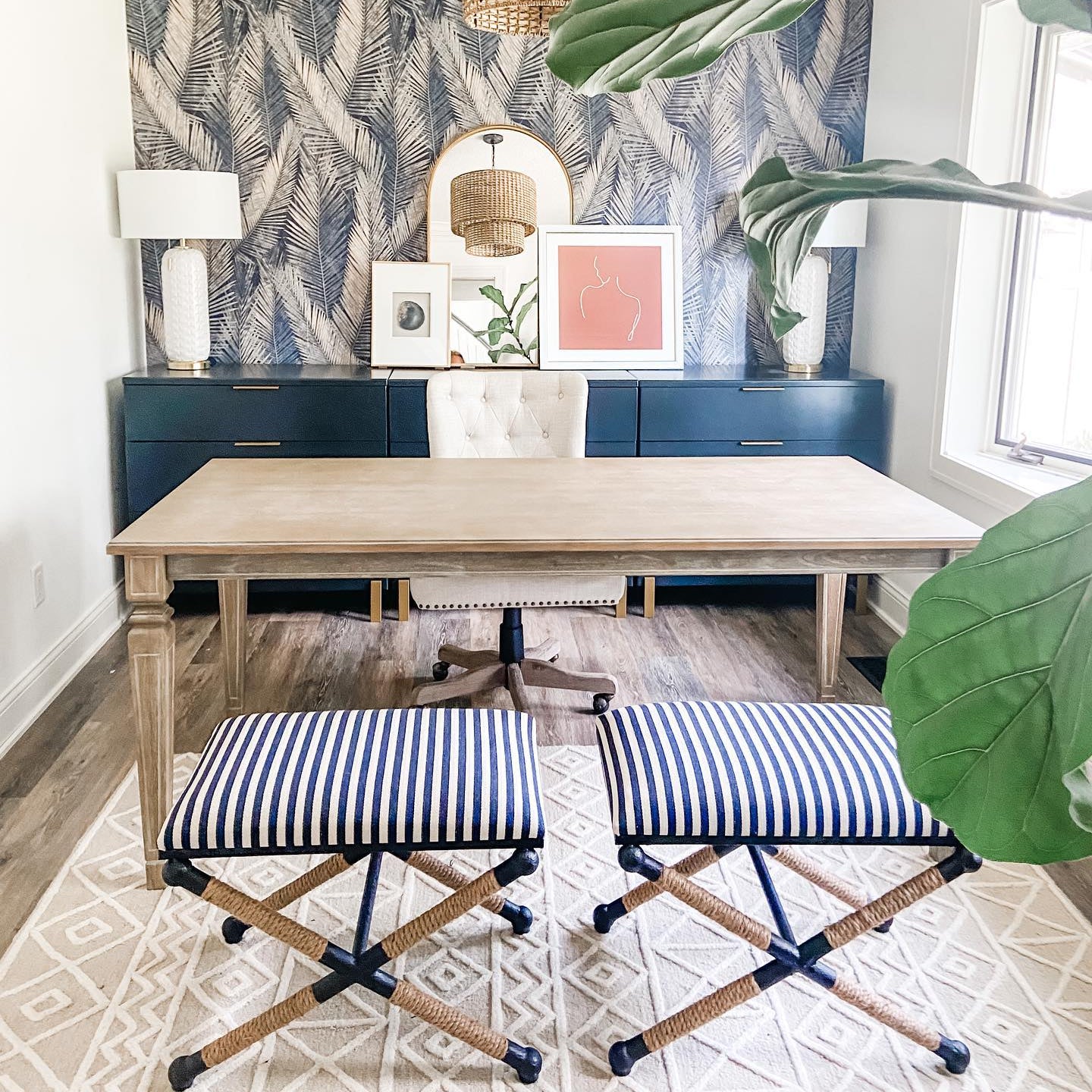 Living room with a wooden table, blue stools with striped cushions, and decorative wall art.