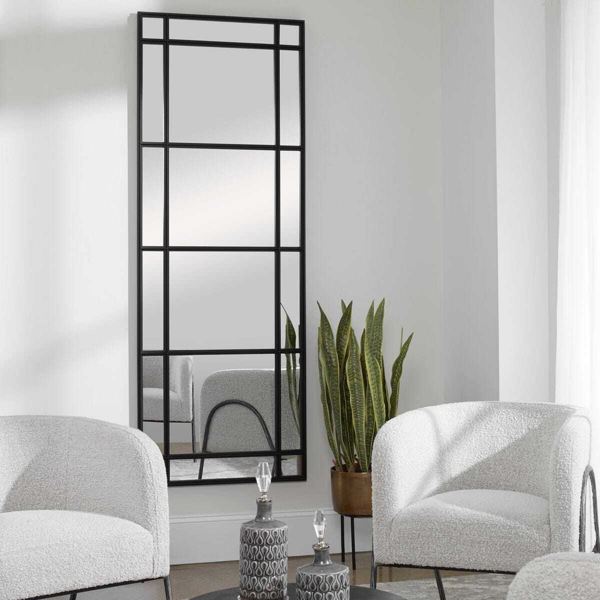 Decorative wall mirror with geometric design in a living room setting.