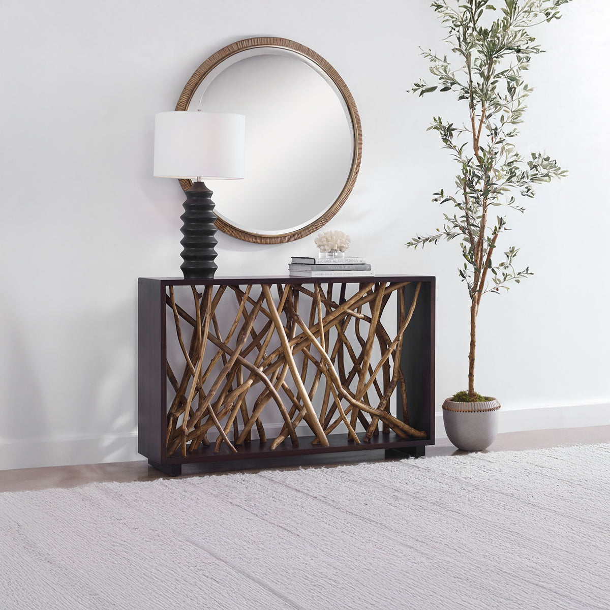 Teak console table wrapped in mahogany with a modern table lamp and an olive tree.