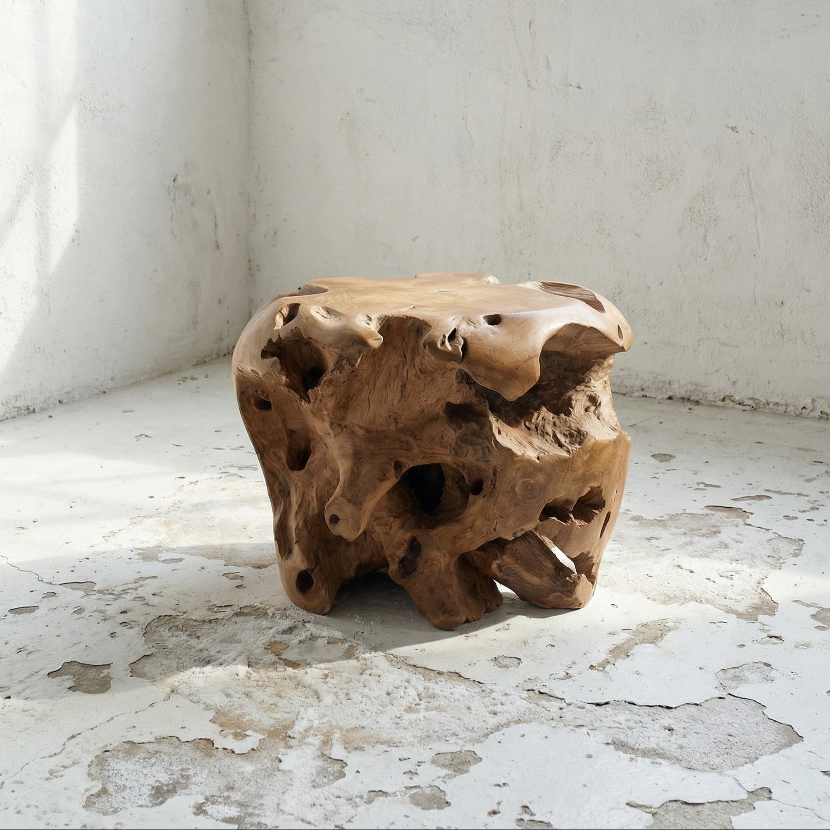 Wooden round teak stool with a natural, textured surface in a minimalistic room.