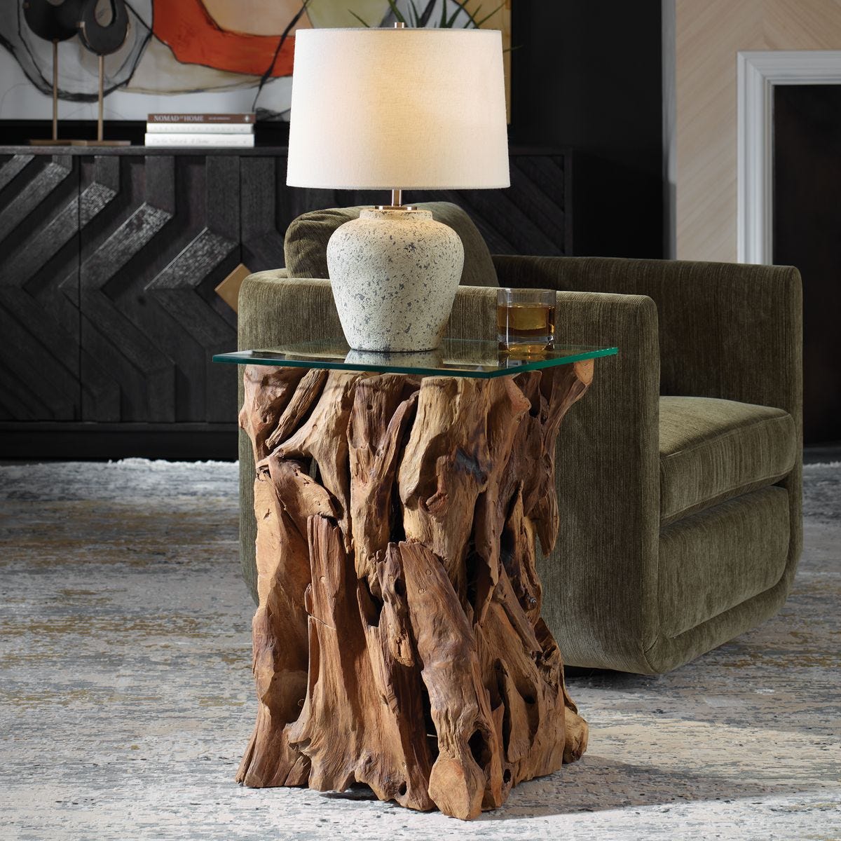 Decorative side table with natural wood base and glass top in a living room setting.