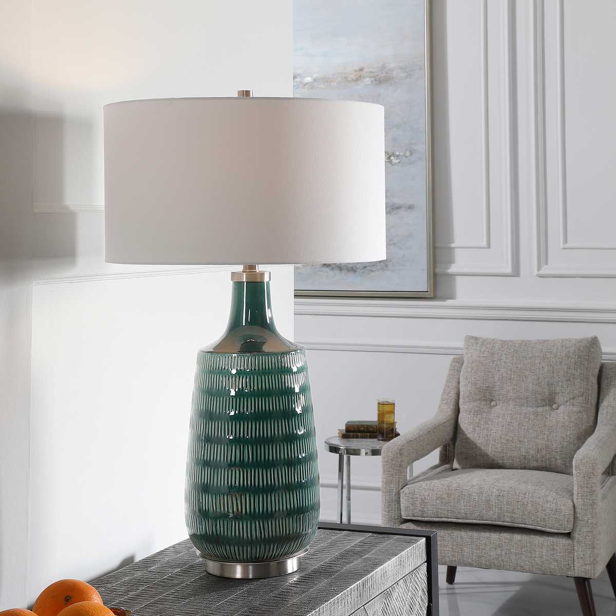 Green ceramic table lamp with white shade in a living room setting
