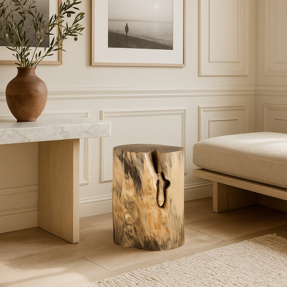 Living room with wooden stool, marble table, and framed artwork on a wall.