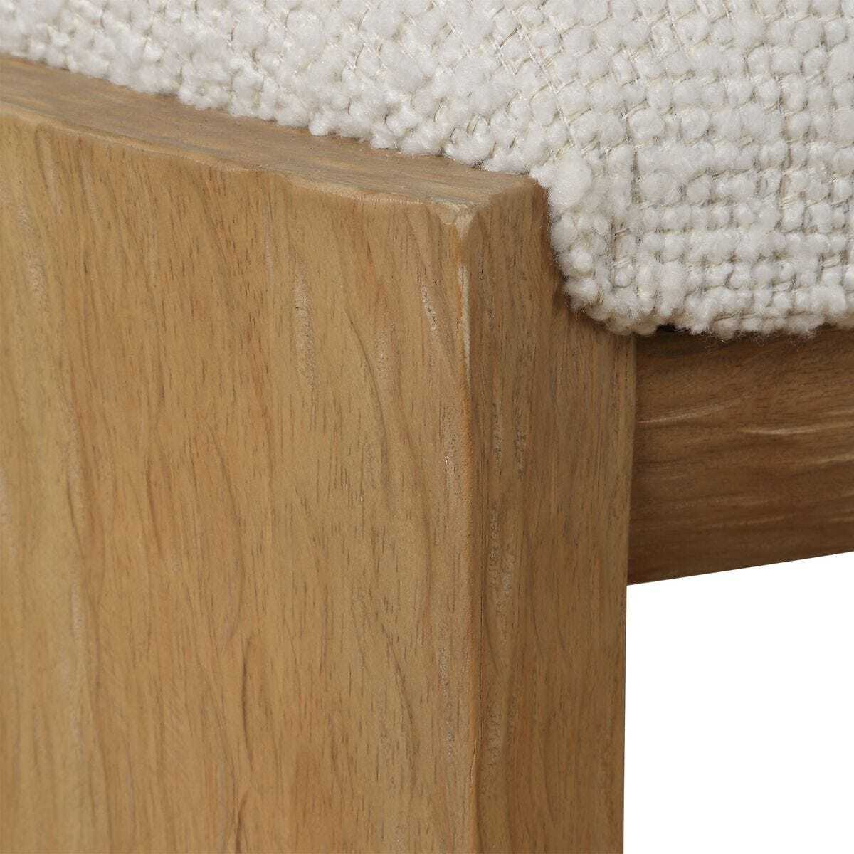 Close-up of a wooden furniture leg against a textured white surface