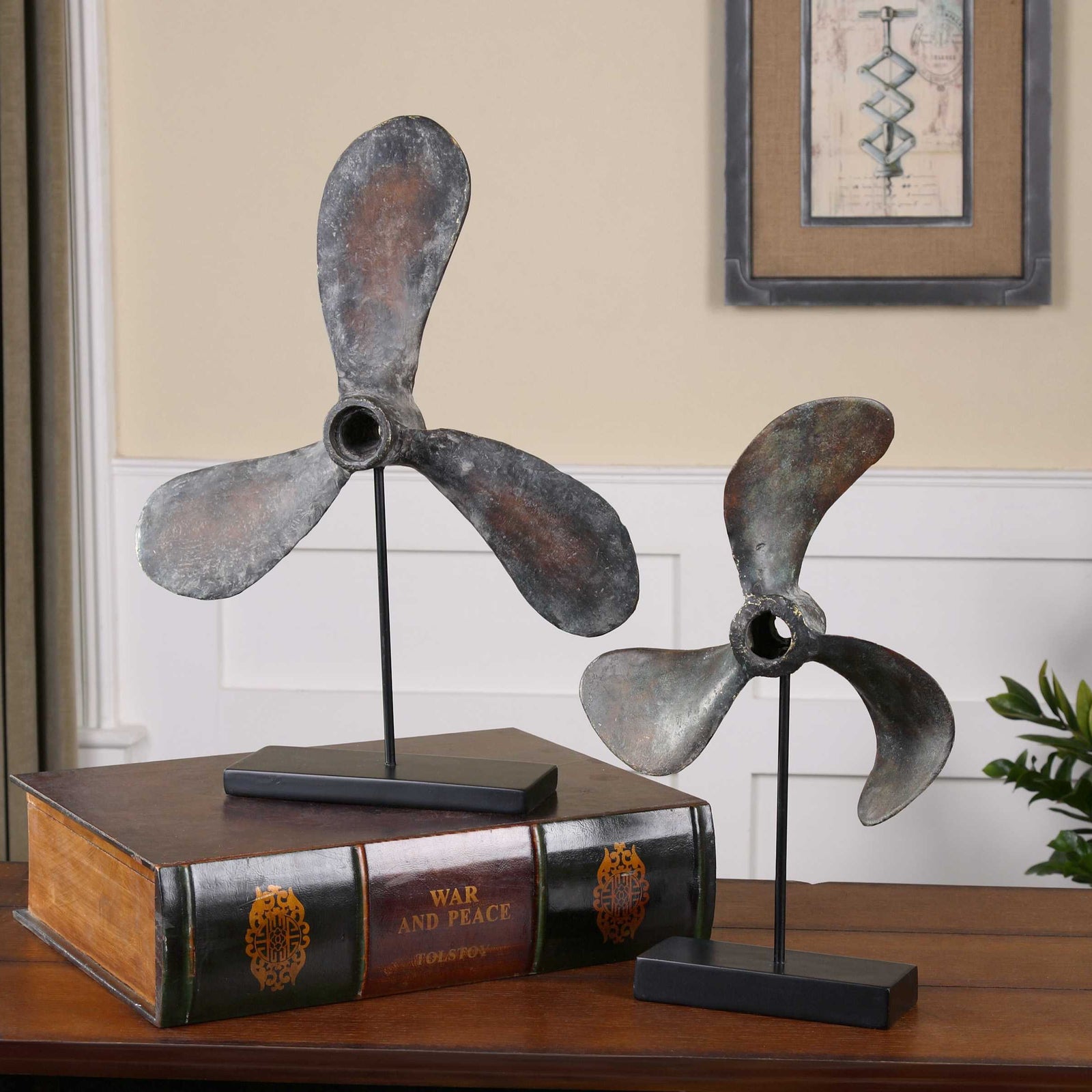 Two vintage coastal boat sculptures on top of a book.