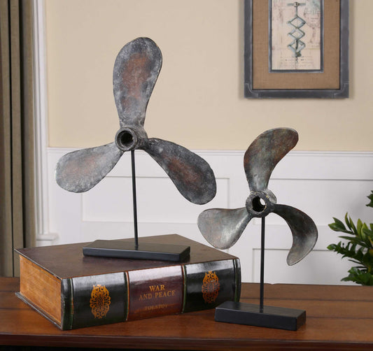 Two vintage coastal boat sculptures on top of a book.