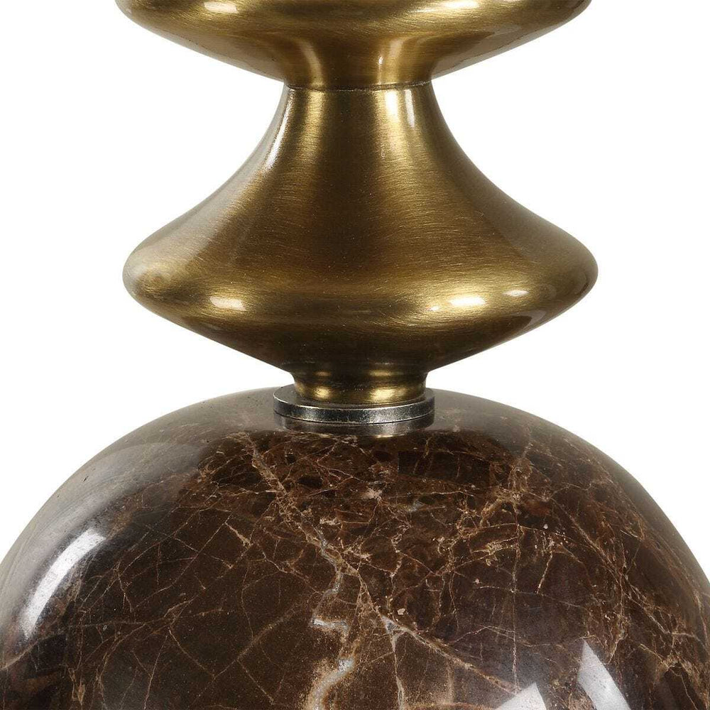 Decorative table lamp with brass stem and brown marble base on a white background
