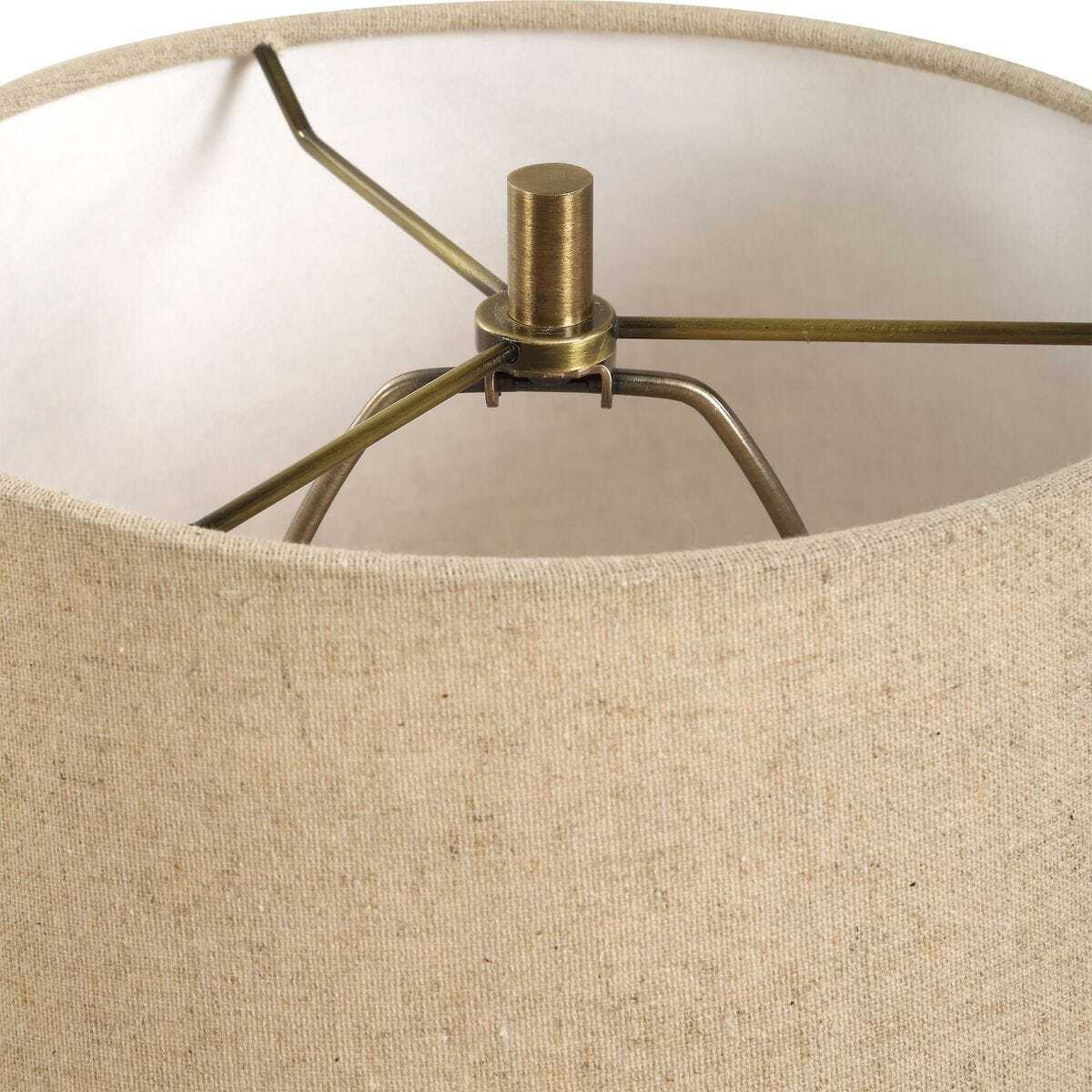 Close-up of a lamp with beige fabric shade and brass fitting.