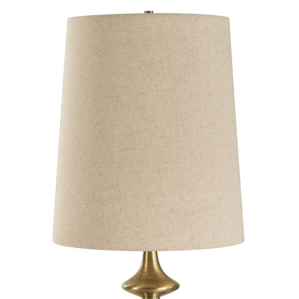 Table lamp with beige lampshade and gold base on a white background