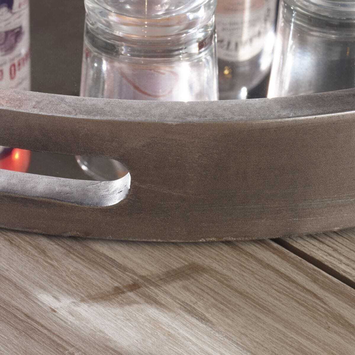 Close-up of a metal tray on a wooden surface with glass containers in the background.