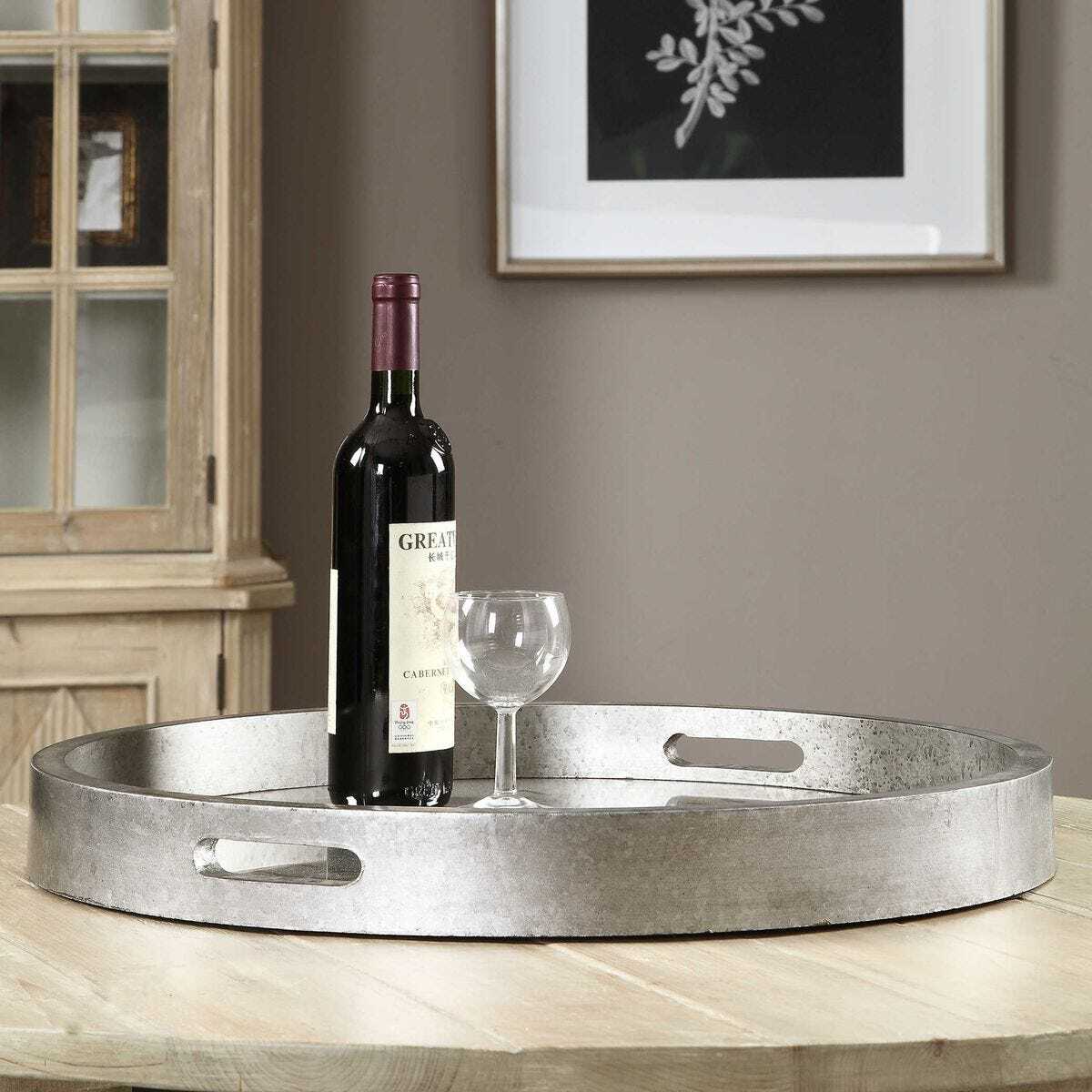 Wine bottle and glass on a metal tray in a home setting