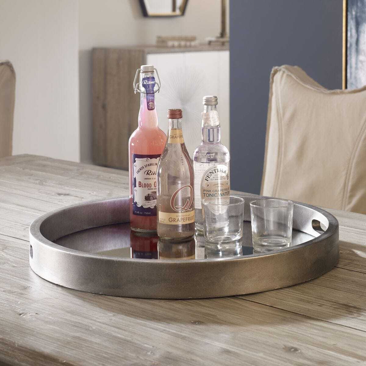 Tray with bottles and glasses on a wooden table