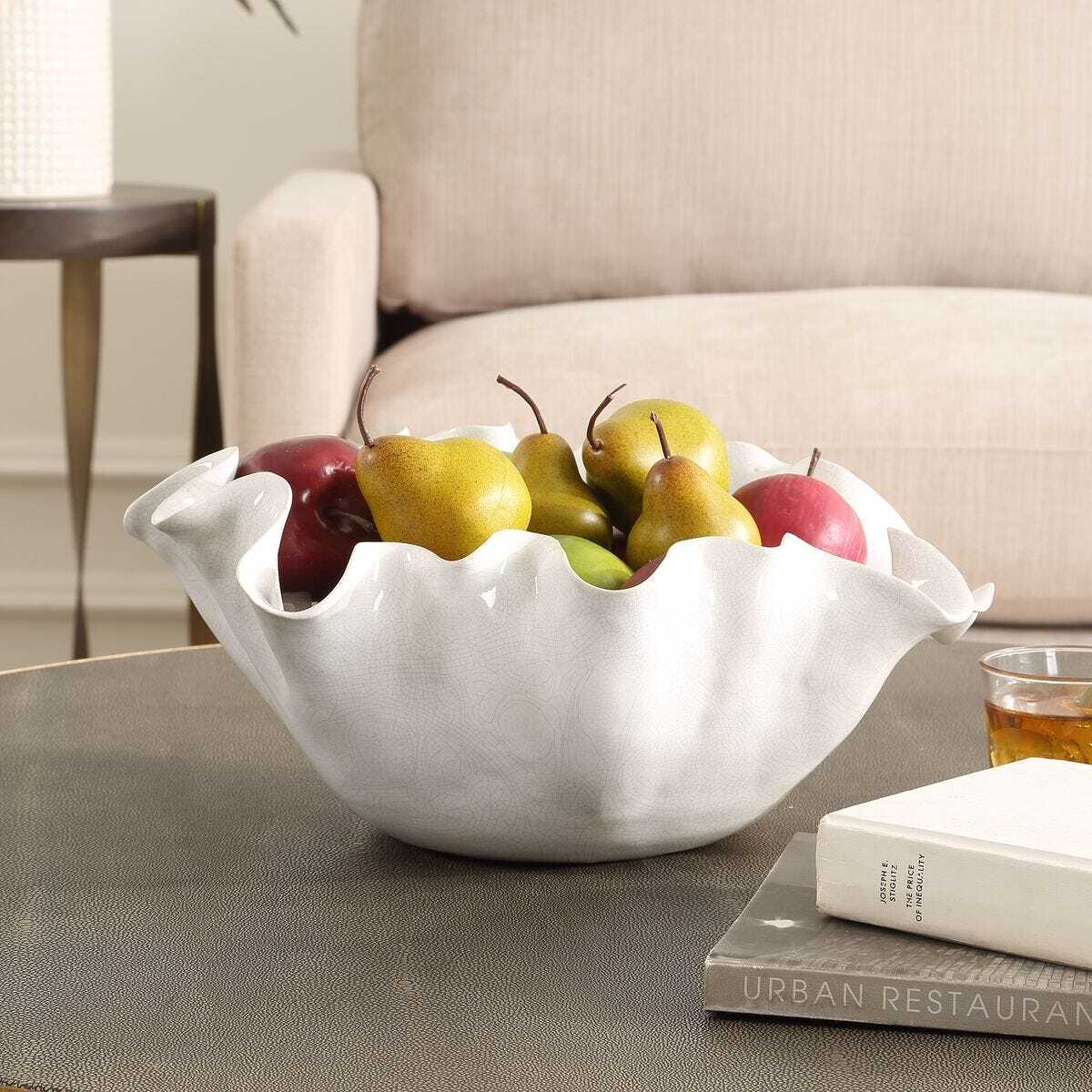 White ceramic bowl with fruits on a coffee table in a living room setting
