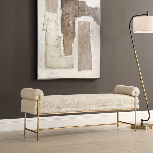 White boucle bench with gold frame and abstract textured piece of art in living room with floor lamp.