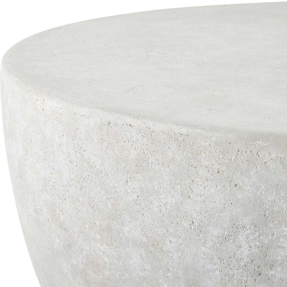 Close-up of a round concrete side table or stool with a textured light gray finish, showing the top surface and side edge against a white background.