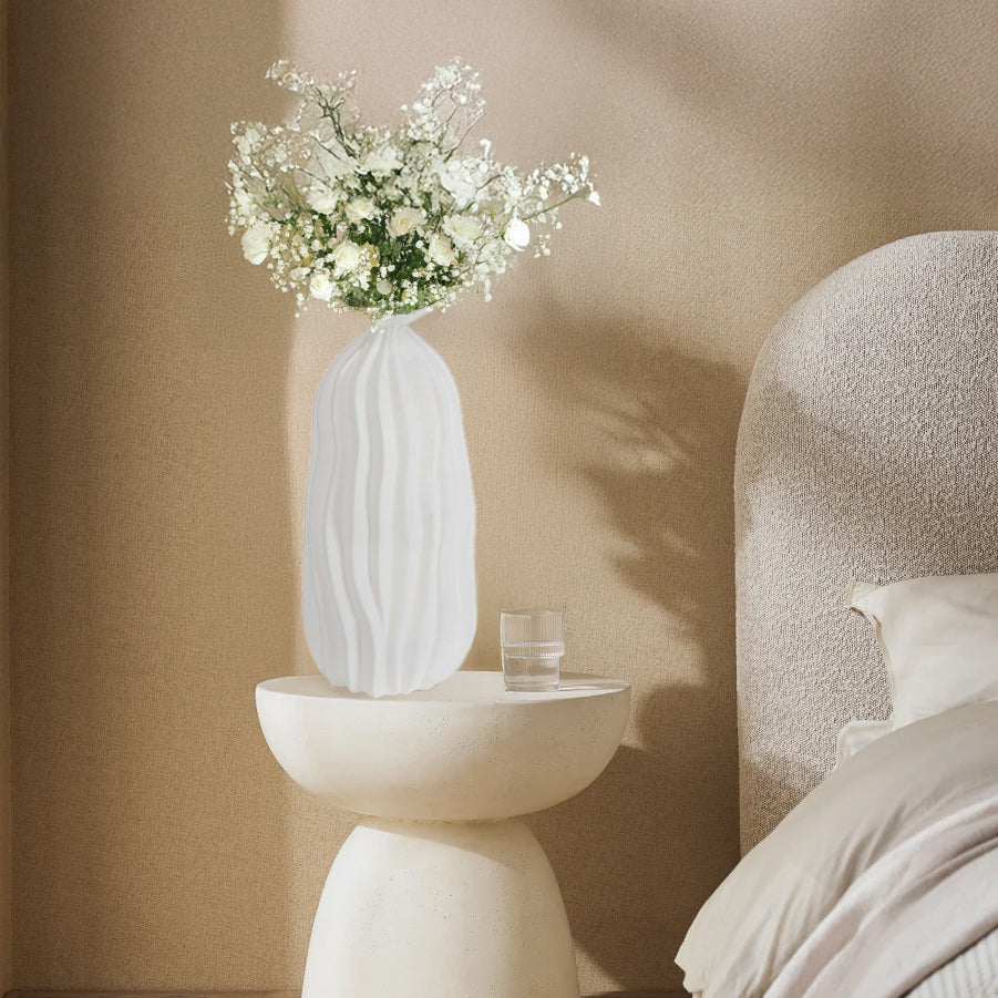 Large white decorative white vase in boho chic bedroom with boucle bed.