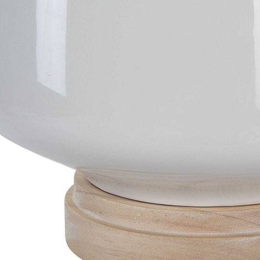 Table lamp with a white ceramic base and beige fabric shade on a white background