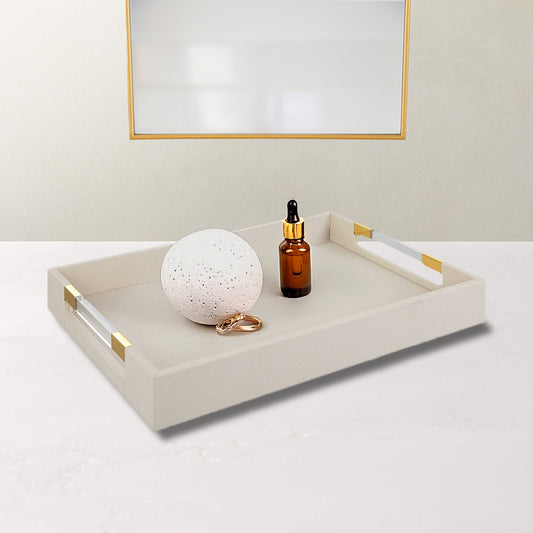 White and gold glam tray in fake leather shagreen and holding decorative stone orb, rings, and jewelry.