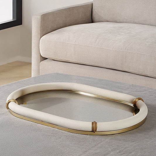 Gold and white shagreen tray marble on gray ottoman in living room.