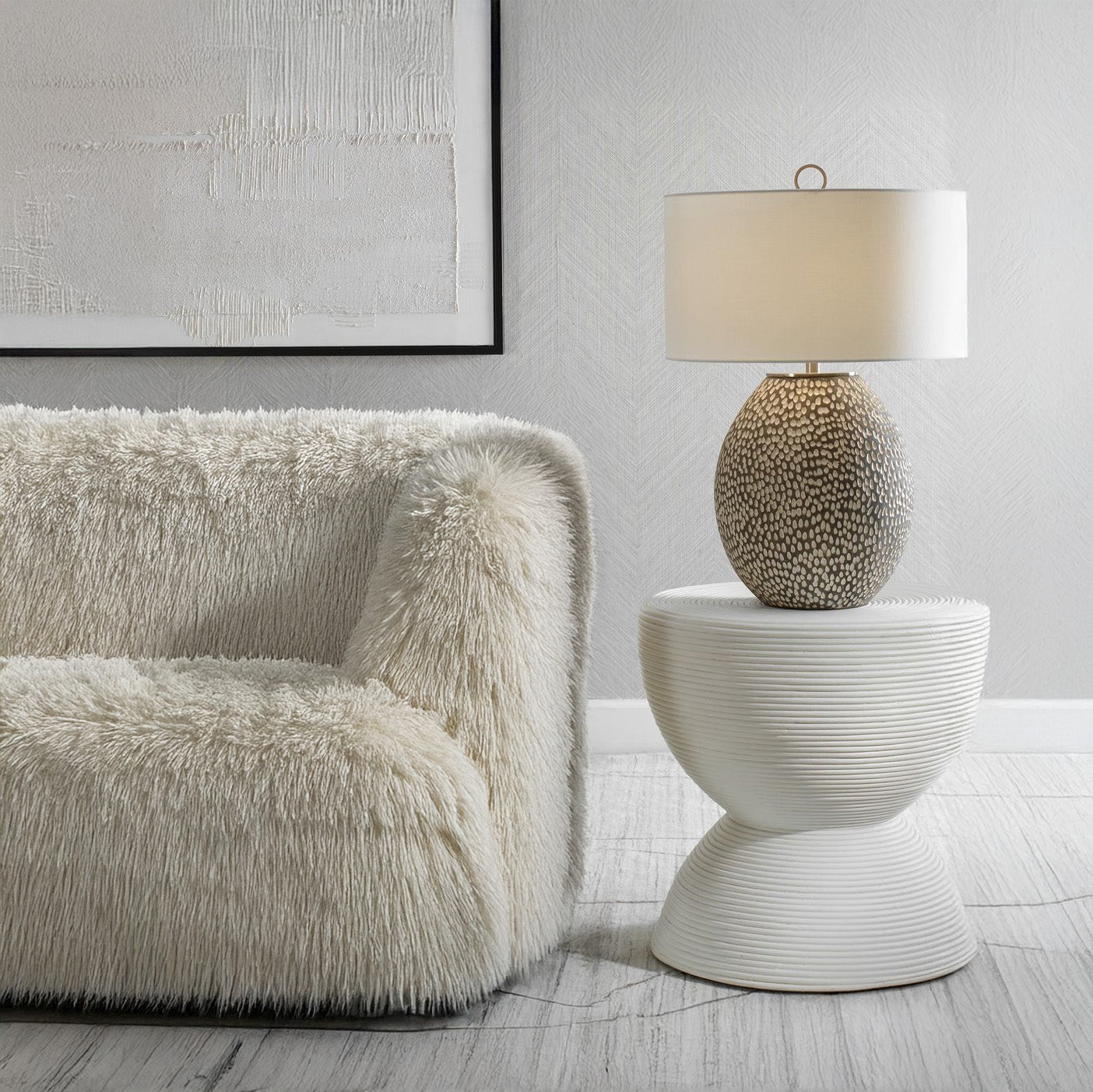 White boucle sofa and white hourglass side table in living room.