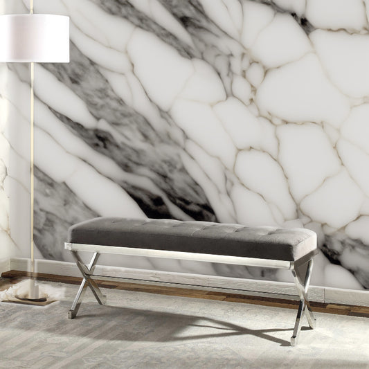 Gray tufted bench and a white marble wall.